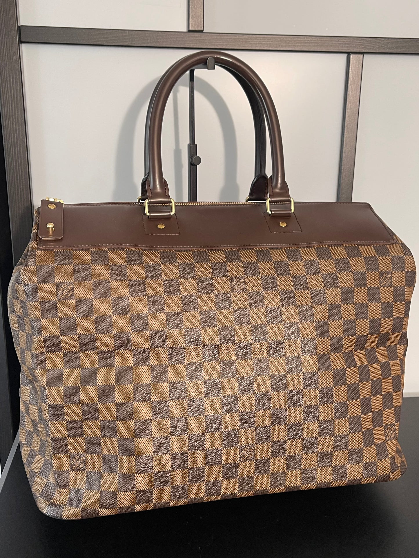 This is a pre-owned Louis Vuitton Brown Damier Ebene Greenwich Handbag/Travel Bag.