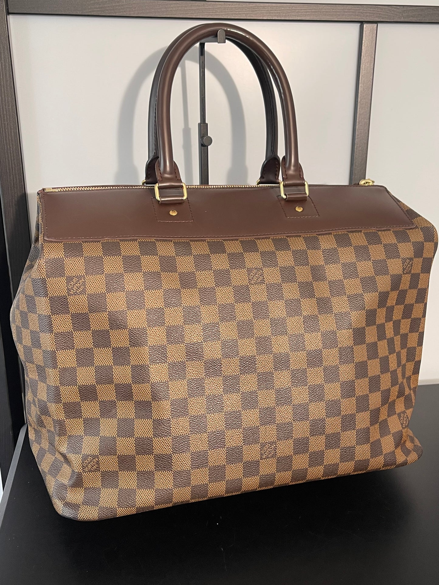 This is a pre-owned Louis Vuitton Brown Damier Ebene Greenwich Handbag/Travel Bag.
